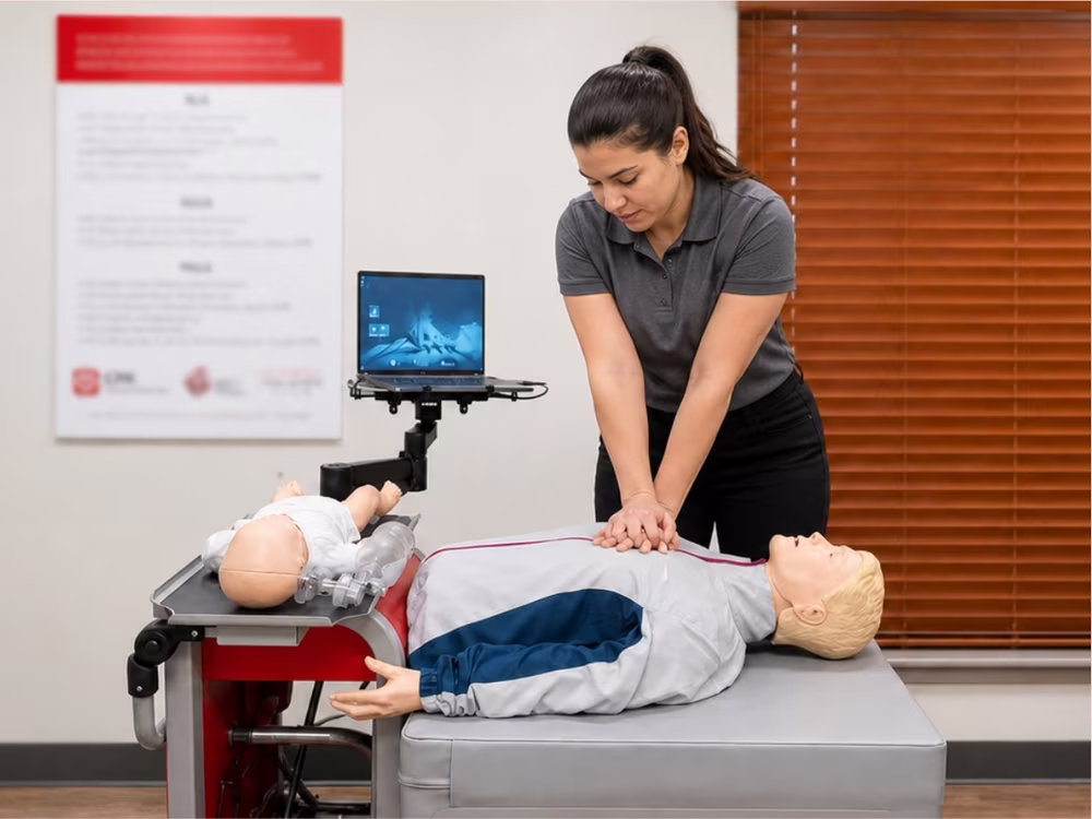 Employee practicing chest compressions on an adult manikin at a CPR Certification Labs skills station