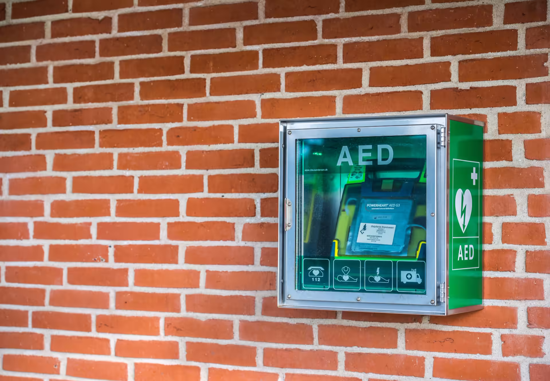 Automated external defibrillator cabinet mounted on a brick wall